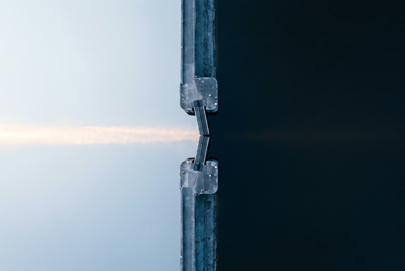 A canal lock seen from directly above, water at two different levels divided by the gates